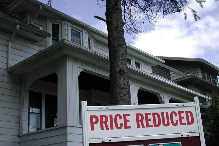 Fixer upper house with a for sale sign